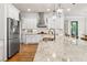 Contemporary kitchen with white cabinets, a stainless steel range hood, and a large center island at 5114 Brendlynn Dr, Suwanee, GA 30024