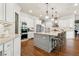 An open kitchen featuring a large island with seating, white cabinetry and stainless steel appliances at 5114 Brendlynn Dr, Suwanee, GA 30024