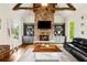 Inviting living room featuring stone fireplace, wood beams, built-in shelving and hardwood floors at 5114 Brendlynn Dr, Suwanee, GA 30024