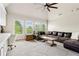 Bright living room featuring built-in cabinets, desk, and large windows showcasing the lush greenery at 5114 Brendlynn Dr, Suwanee, GA 30024