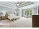Main bedroom featuring trey ceilings, neutral paint, carpet floors, and sitting area with a bench at 5114 Brendlynn Dr, Suwanee, GA 30024