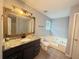 Bathroom featuring a soaking tub, walk-in shower and granite countertop vanity at 2658 Deann Dr, Ellenwood, GA 30294