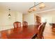 Open dining room with wooden table and chairs, modern pendant lighting, with a view into the kitchen at 2831 Carolyn Se Dr, Smyrna, GA 30080