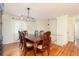 Formal dining room featuring hardwood floors, a classic china cabinet, and a wooden dining set under pendant lighting at 2831 Carolyn Se Dr, Smyrna, GA 30080