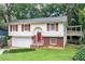 Charming two-story home features red shutters, a brick facade, attached garage, and a lovely deck, enhancing outdoor living at 2831 Carolyn Se Dr, Smyrna, GA 30080