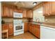 Functional kitchen featuring wood cabinets, white appliances, and a well-lit sink area at 2831 Carolyn Se Dr, Smyrna, GA 30080