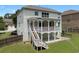 View of the home's backyard with a staircase leading to a second-story porch and well-maintained lawn at 1722 Preserve Creek Way, Loganville, GA 30052