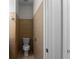 Narrow bathroom featuring neutral tile, toilet, and white doors at 1722 Preserve Creek Way, Loganville, GA 30052