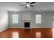 Spacious living room featuring a fireplace, two windows, and gleaming hardwood floors at 1722 Preserve Creek Way, Loganville, GA 30052