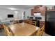 Eat-in kitchen featuring wood cabinets, black appliances, and a rustic wood dining table at 2567 Hancock Rd, Social Circle, GA 30025
