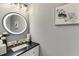 Modern bathroom with a round mirror, decorative lighting, and stylish countertops at 4171 Lantern Hill Dr, Dacula, GA 30019