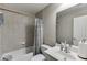Tiled bathroom features tub and shower combo, single vanity, and framed mirror at 4171 Lantern Hill Dr, Dacula, GA 30019