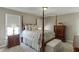 Bedroom with four-poster bed, matching dressers, bench and neutral color scheme at 4171 Lantern Hill Dr, Dacula, GA 30019