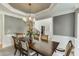 Formal dining room features a stylish chandelier, neutral walls, and a large dark-wood table at 4171 Lantern Hill Dr, Dacula, GA 30019