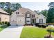 Charming two-story home with a manicured front yard, three-car garage, stone accents, and covered entrance at 4171 Lantern Hill Dr, Dacula, GA 30019