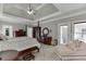 Bright main bedroom with a four-poster bed, sitting area, and view to outdoor balcony at 4171 Lantern Hill Dr, Dacula, GA 30019