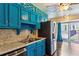 Kitchen with custom turquoise cabinetry, granite countertops, and stainless steel appliances at 6889 Kingsboro Dr, Lithia Springs, GA 30122