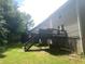 Exterior view of a home with a backyard, wooden deck, and lush green surroundings at 8951 Stonebridge Blvd, Douglasville, GA 30134