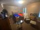 Bedroom featuring a bed, fan, window, and various items scattered throughout the space at 8957 Stonebridge Blvd, Douglasville, GA 30134