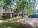 Exterior view of townhomes with lawn and mature trees, showing a residential neighborhood at 8957 Stonebridge Blvd, Douglasville, GA 30134