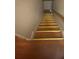 Wooden staircase with yellow tread trim and a wooden handrail leading down to a wooden floor at 8957 Stonebridge Blvd, Douglasville, GA 30134