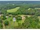 A beautiful aerial view of a home surrounded by lush greenery and a nearby meadow, creating a serene and private setting at 4444 Cannon Sw Rd, Loganville, GA 30052