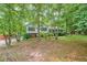 A welcoming exterior view of a cozy home, framed by mature trees and landscaped gardens, offering a peaceful retreat at 4444 Cannon Sw Rd, Loganville, GA 30052