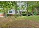 A welcoming exterior view of a cozy home, framed by mature trees and landscaped gardens, offering a peaceful retreat at 4444 Cannon Sw Rd, Loganville, GA 30052