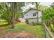 Exterior view of the home and backyard, with lush green grass and mature trees at 4444 Cannon Sw Rd, Loganville, GA 30052