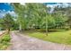 A charming front yard featuring a long driveway, well-maintained lawn, and mature trees, enhancing the home's curb appeal at 4444 Cannon Sw Rd, Loganville, GA 30052