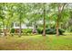 Charming home with a well-manicured front lawn, mature trees, and a cozy bench at 4444 Cannon Sw Rd, Loganville, GA 30052