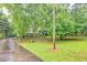 A charming front yard featuring a long driveway, well-maintained lawn, and mature trees, enhancing the home's curb appeal at 4444 Cannon Sw Rd, Loganville, GA 30052