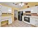 Bright kitchen featuring black appliances, desk nook, and decorative brick backsplash at 4444 Cannon Sw Rd, Loganville, GA 30052