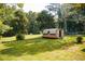 Spacious, green backyard featuring a storage shed, trampoline, and mature trees at 4565 Deerfield Dr, Cumming, GA 30028