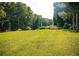 Expansive backyard featuring lush green grass and mature trees at 4565 Deerfield Dr, Cumming, GA 30028