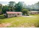 Charming single-story home with red metal roof, a garage, and a spacious front yard at 4565 Deerfield Dr, Cumming, GA 30028