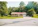Quaint brick home with a red metal roof, front porch, and a well-maintained lawn at 4565 Deerfield Dr, Cumming, GA 30028