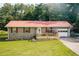 Charming single-story home with a red metal roof, brick facade, and inviting front porch at 4565 Deerfield Dr, Cumming, GA 30028