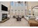 Sun-lit living room boasts tall windows, soaring ceilings, and inviting fireplace at 6350 Old Wood Hollow Way, Buford, GA 30518