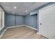 Finished basement room featuring laminate flooring, painted brick accents, and drop ceiling at 90 Barrington Grange Dr, Sharpsburg, GA 30277