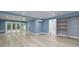 Finished basement with wood flooring, white trim, shelving, and access to the backyard at 90 Barrington Grange Dr, Sharpsburg, GA 30277