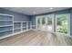 Finished basement with wood flooring, shelving, and doors to the backyard at 90 Barrington Grange Dr, Sharpsburg, GA 30277