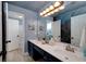 Bright bathroom with double sinks, an ocean-themed mural, and plenty of lighting at 90 Barrington Grange Dr, Sharpsburg, GA 30277