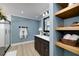 Bathroom featuring double sink vanity, glass shower, and wood shelves with decor at 90 Barrington Grange Dr, Sharpsburg, GA 30277