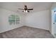 Spacious bedroom featuring neutral carpet, ceiling fan, and large window for ample natural light at 90 Barrington Grange Dr, Sharpsburg, GA 30277