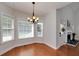 Sunlit dining room with hardwood floors, a chandelier, and views of the fireplace and backyard at 90 Barrington Grange Dr, Sharpsburg, GA 30277