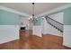 The dining room features hardwood floors, teal walls with white wainscoting, and a view of the living room at 90 Barrington Grange Dr, Sharpsburg, GA 30277