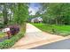 Long driveway leading to a beautiful home surrounded by lush greenery and trees at 90 Barrington Grange Dr, Sharpsburg, GA 30277