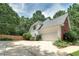 Beautifully landscaped home featuring a two-car garage and a large concrete driveway at 90 Barrington Grange Dr, Sharpsburg, GA 30277