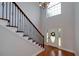 Elegant foyer featuring a staircase with iron railing, hardwood floors, and a front door at 90 Barrington Grange Dr, Sharpsburg, GA 30277